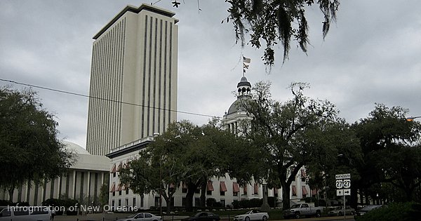 Florida Old Capitol building with white columns and red striped awning beside modern New Capitol tower in Tallahassee